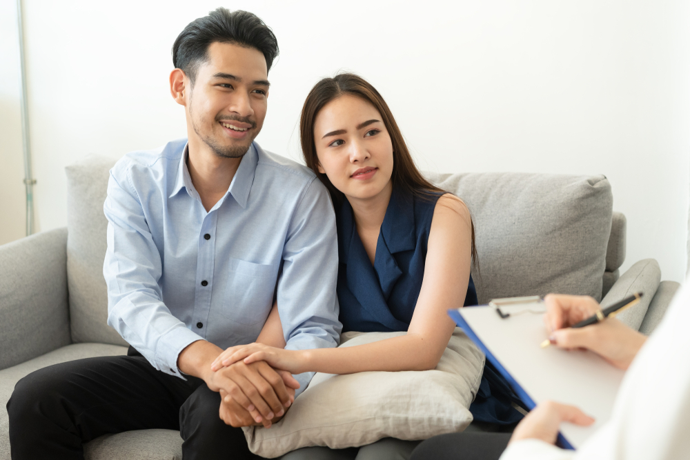 Asian couple holding hands and attending pre marriage counselling