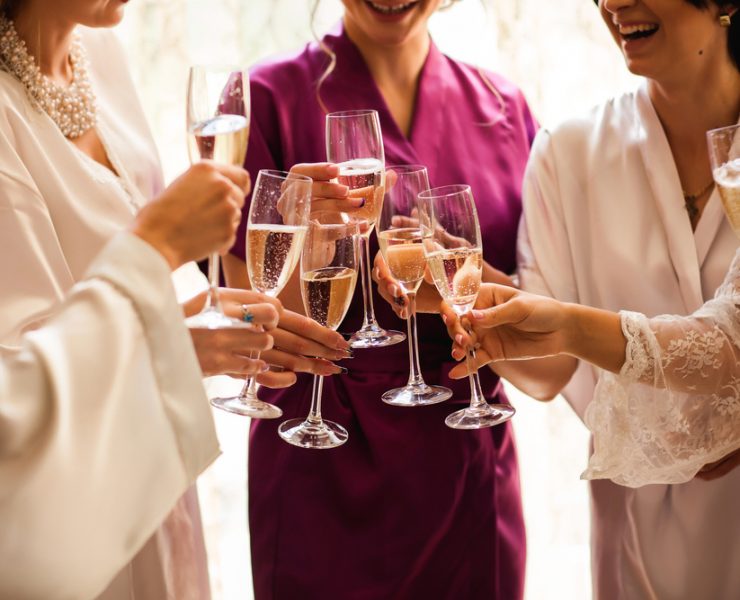 Bride and bridesmaids celebrate and drinking champagne