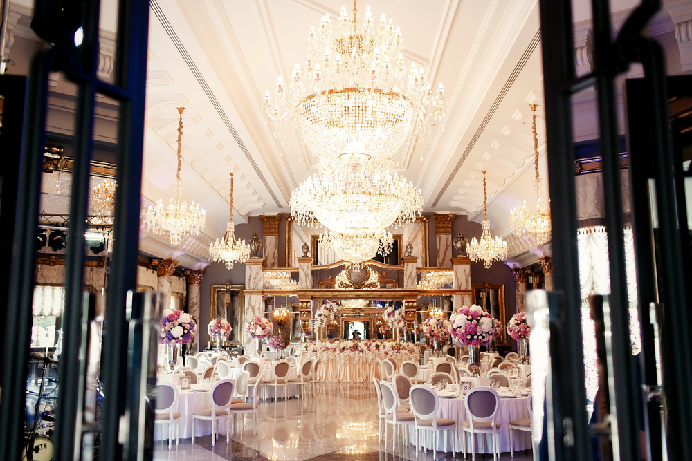 Look from afar at luxurious restaurant hall prepared for wedding dinner