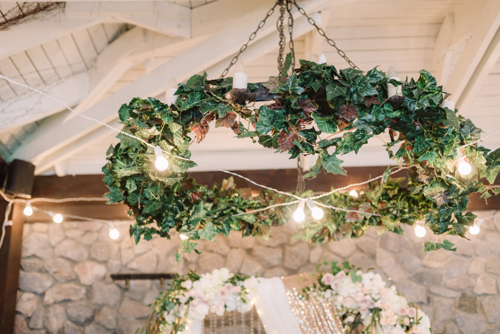 The round chandelier decorated with green leaves.