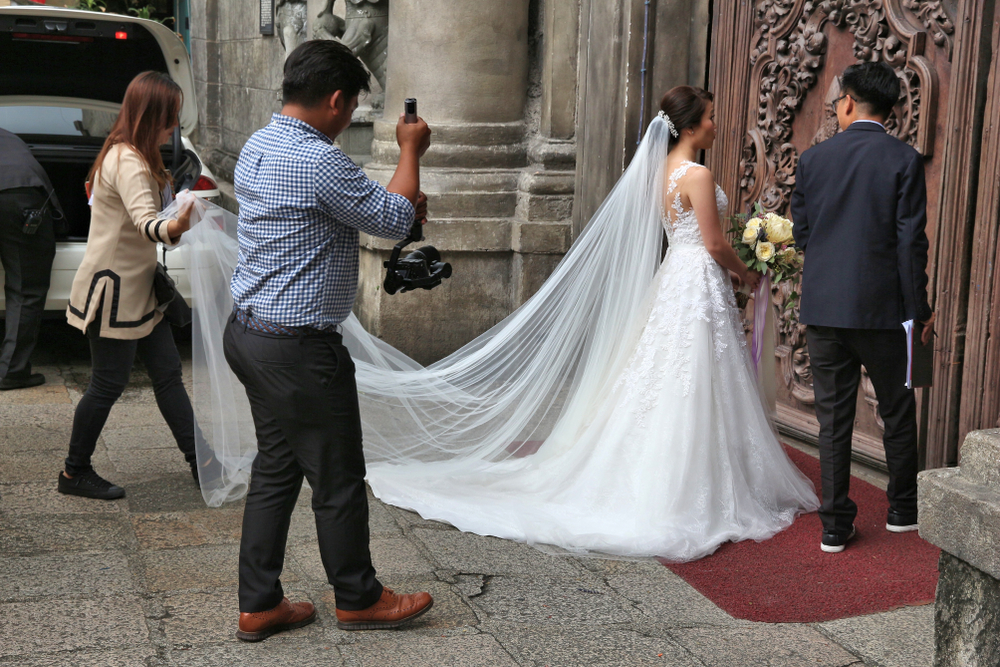 Wedding photographer takes photos of the bride and groom entering church