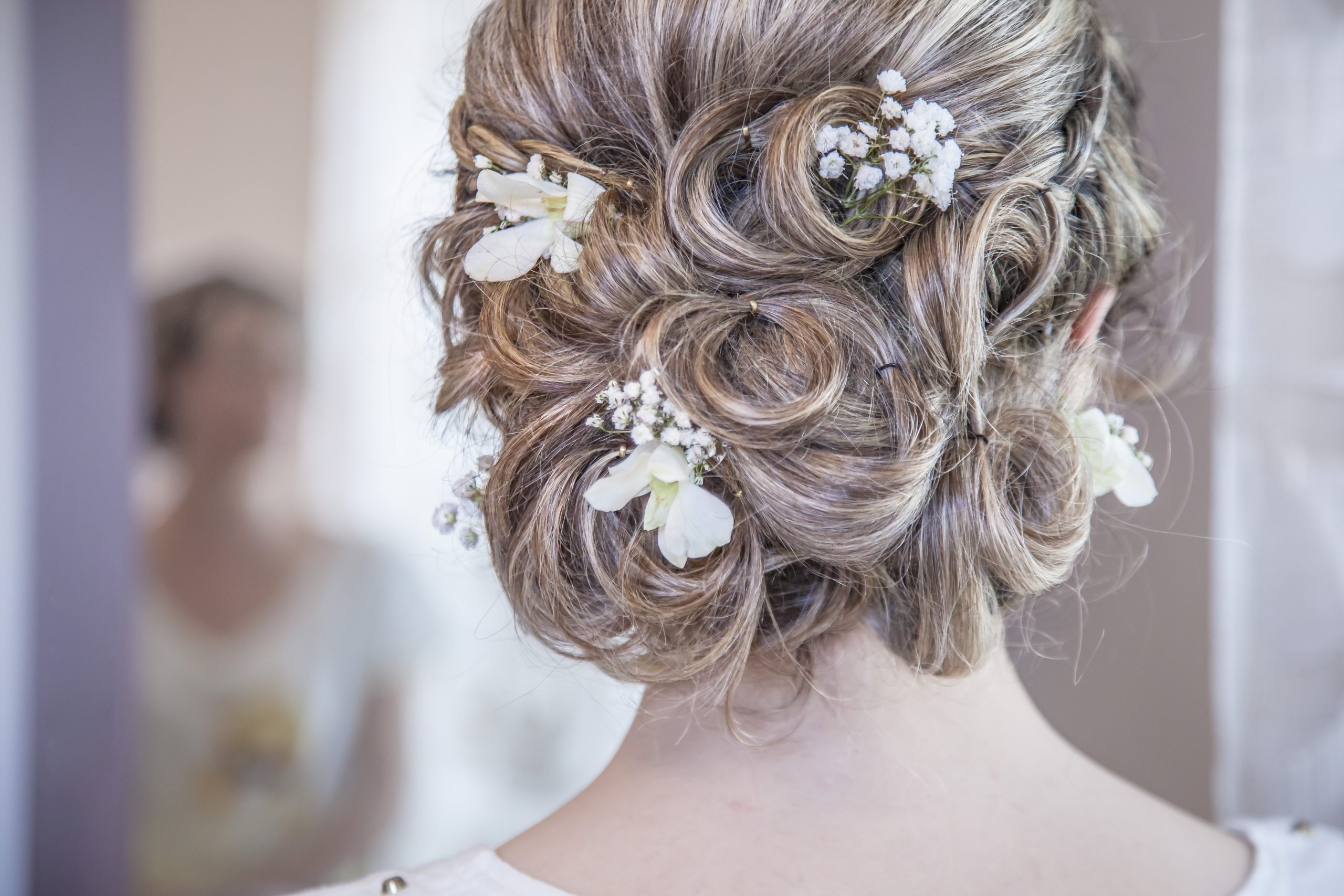 backview of a bride's hair with white flowers