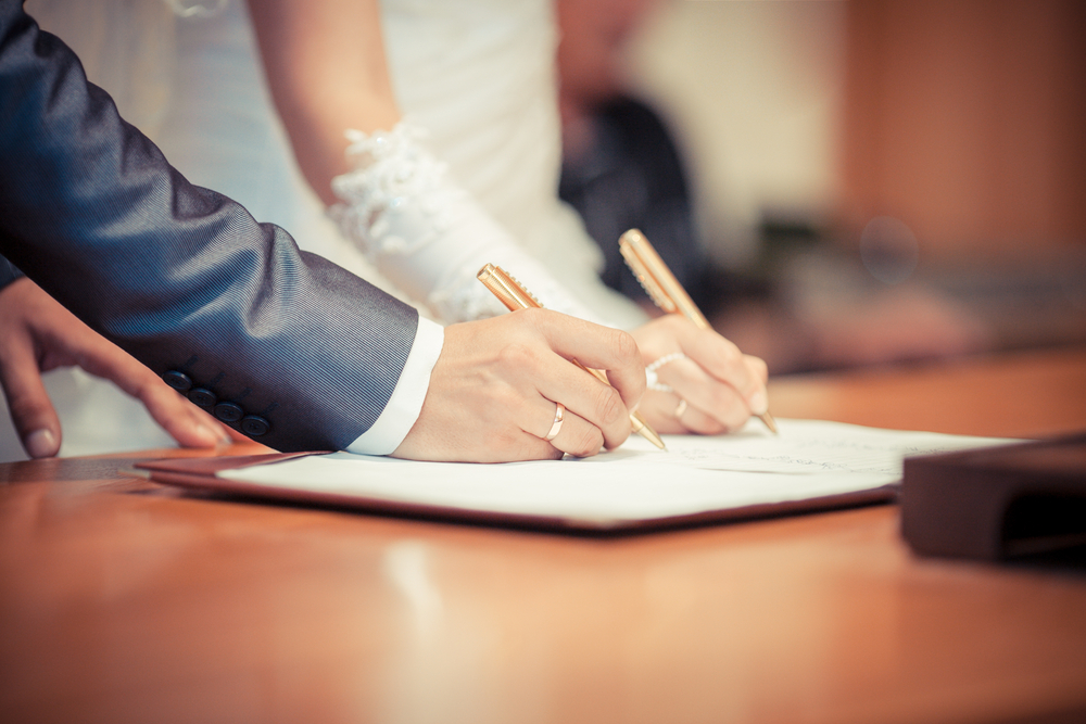 bride and groom signing marriage contract 