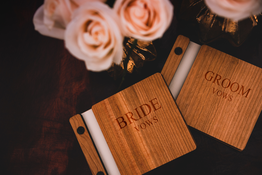 bride and groom wedding vows print on wooden board with bouquet of flowers