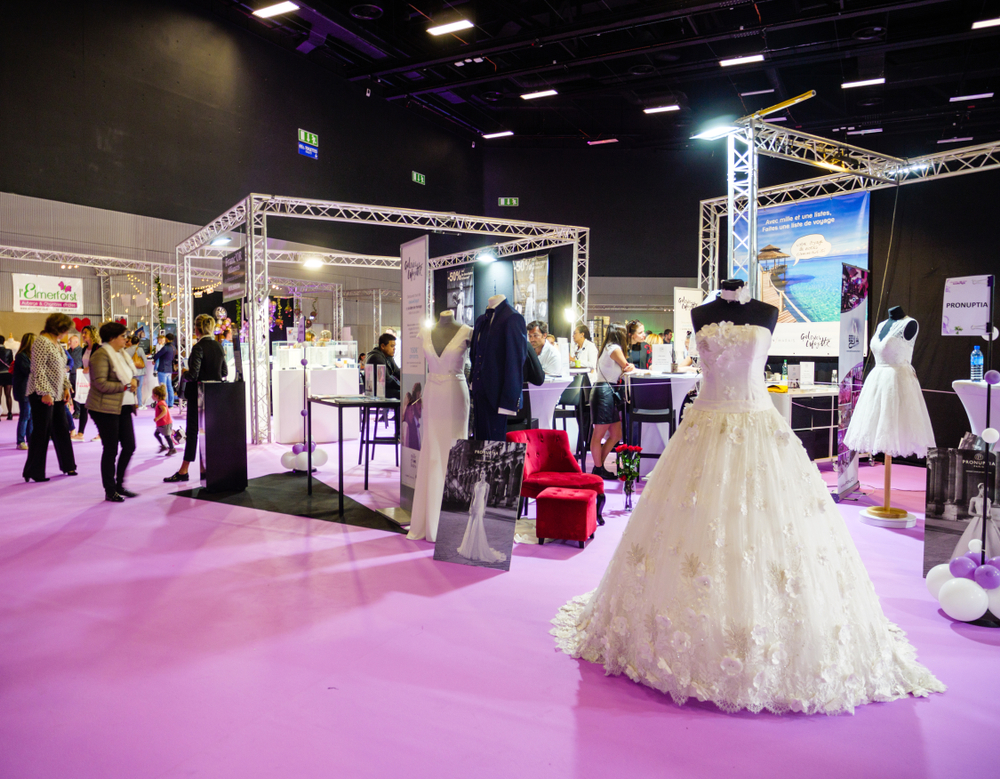 wedding expo with beautiful wedding dresses and people in background