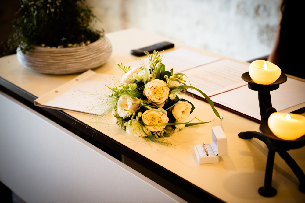 the bridal bouquet, rings, and candles on table civil registry office