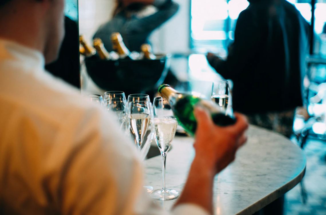 wedding entourage - wine bottle pouring on glass