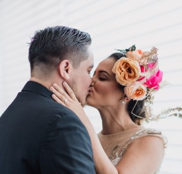 Bride wearing flower crown and groom kissing
