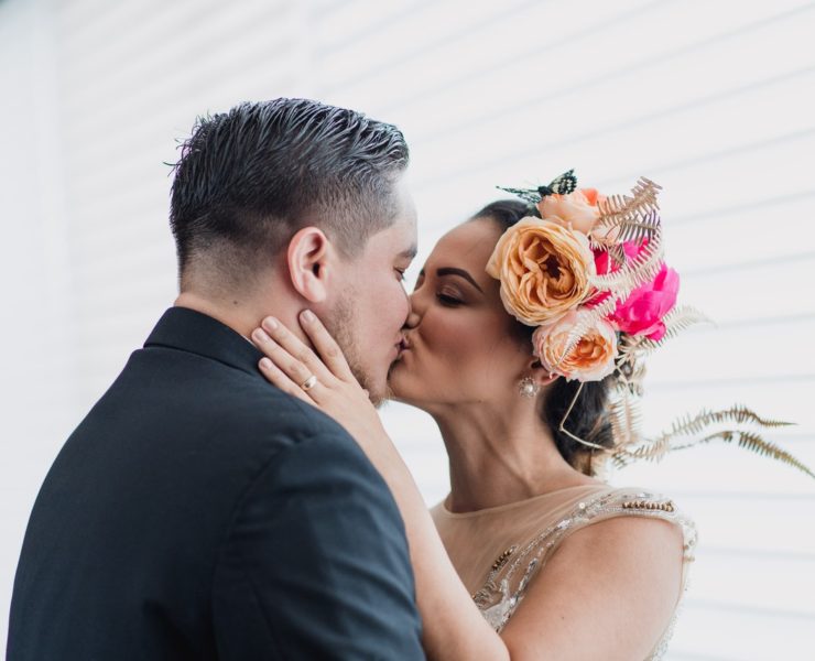 Bride wearing flower crown and groom kissing