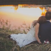 newly wed couple sitting by the river