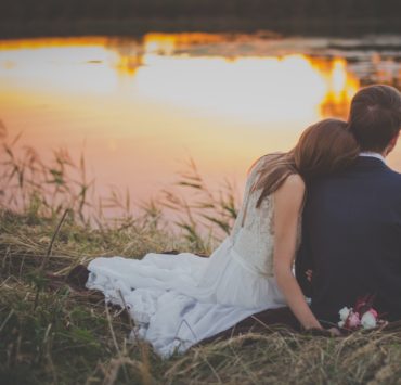 newly wed couple sitting by the river