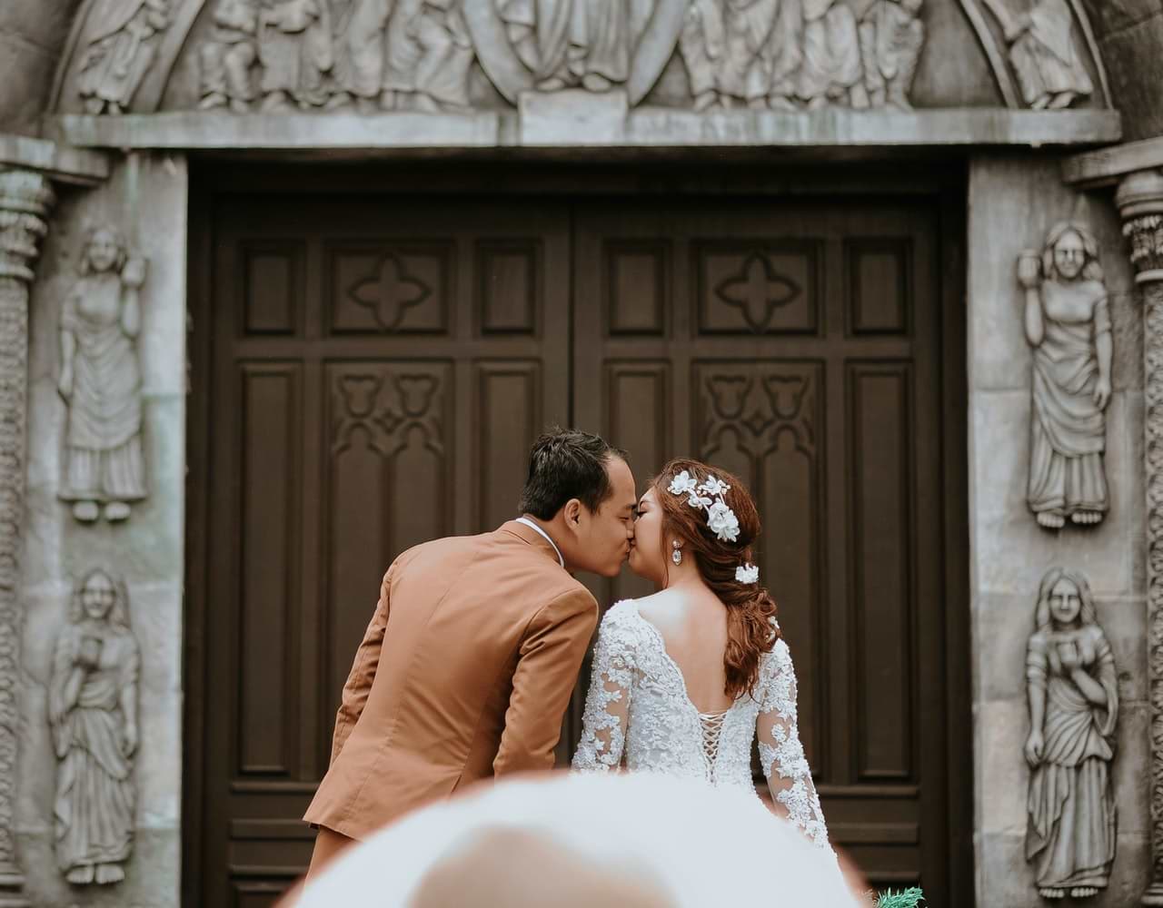 Filipino couple kiss outside church