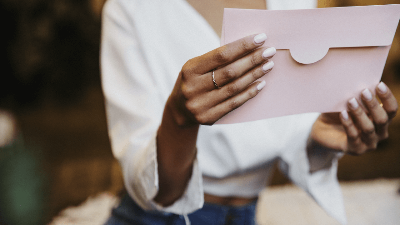 woman with wedding ring holding a letter