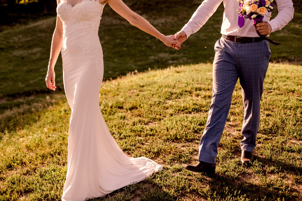 Bride and groom holding hands and walking down the hill