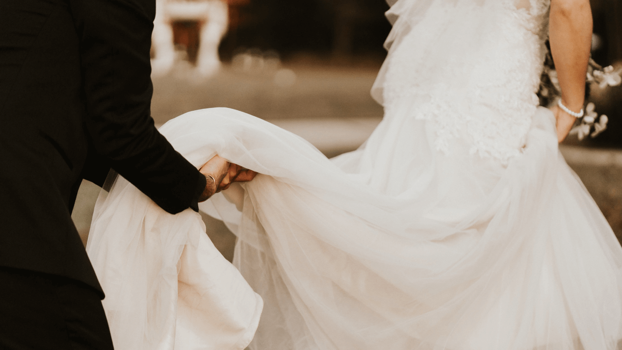 groom holding brides' dress train