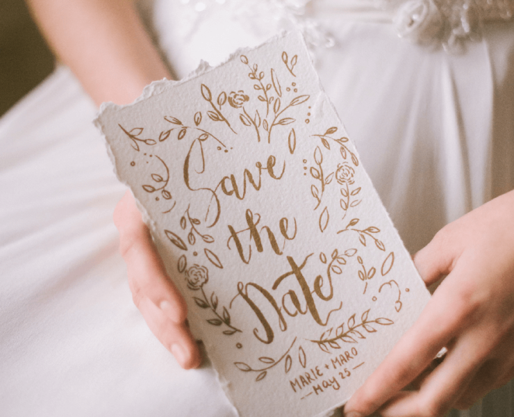 Bride holding a card with Save the Date written on it
