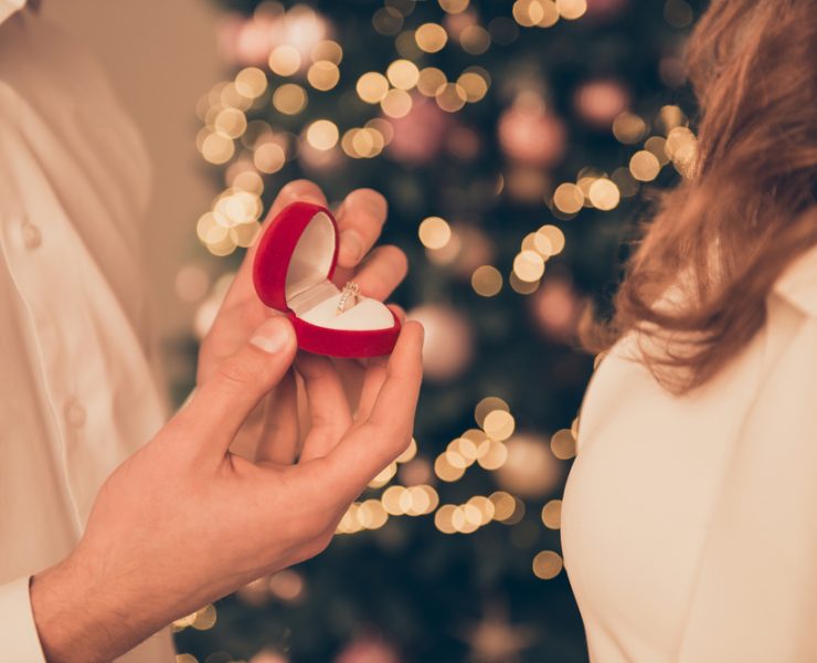 close up of man and woman during proposal on Christmas