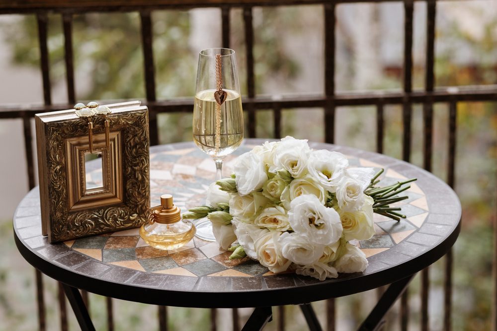 white flower bouquet, vintage earrings, champagne, vintage perfume at the round table