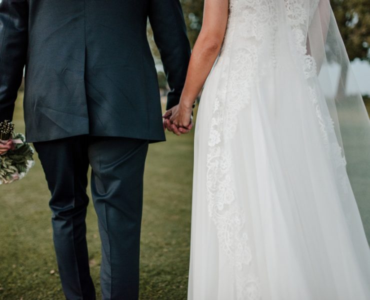 young couple holding hands newlyweds in the field