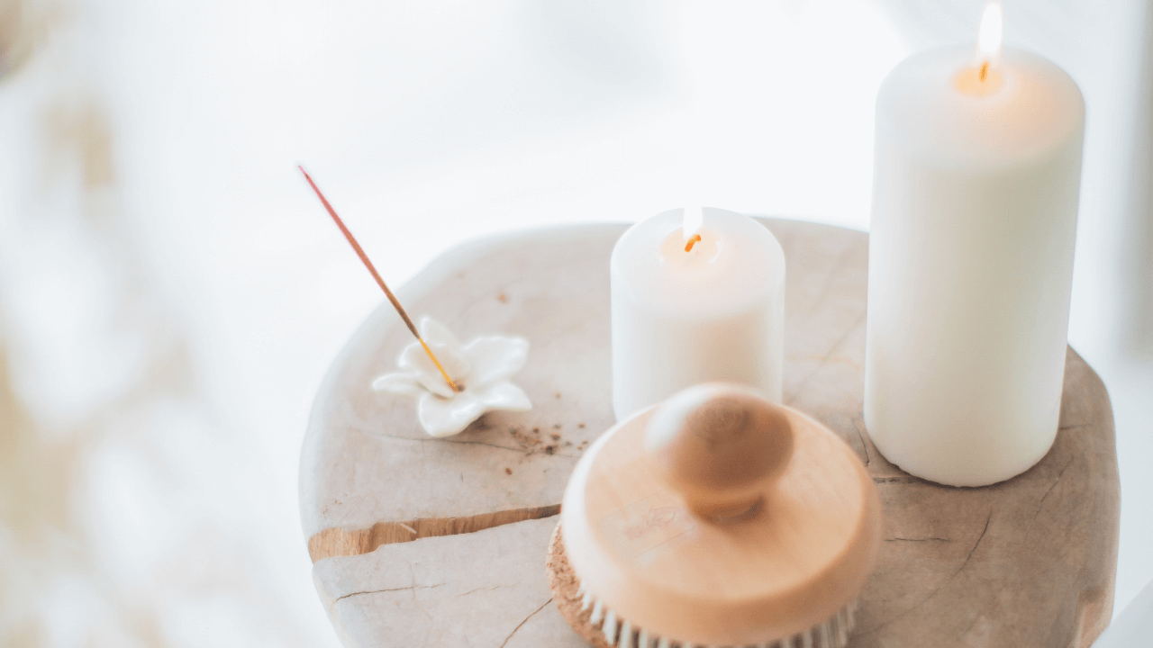 two white candles on top of wood