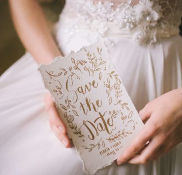 close up of Save The Date card on bride's hands