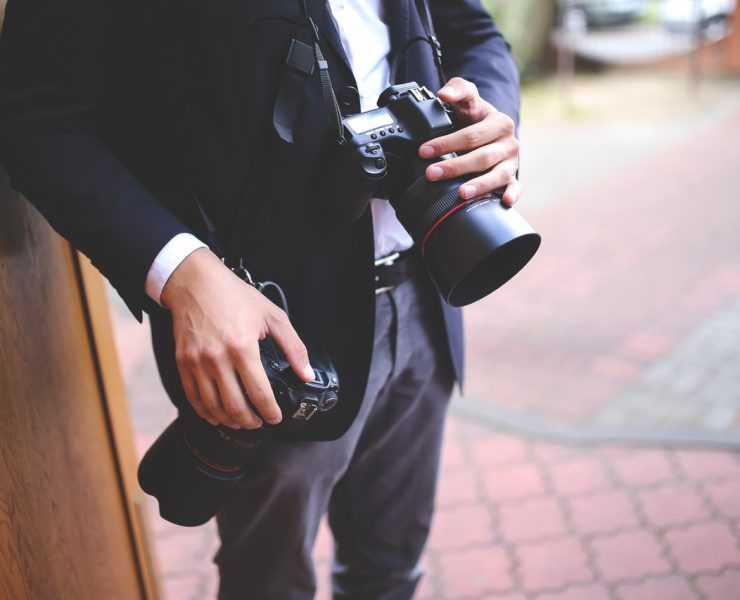 a wedding photographer stands at the ready