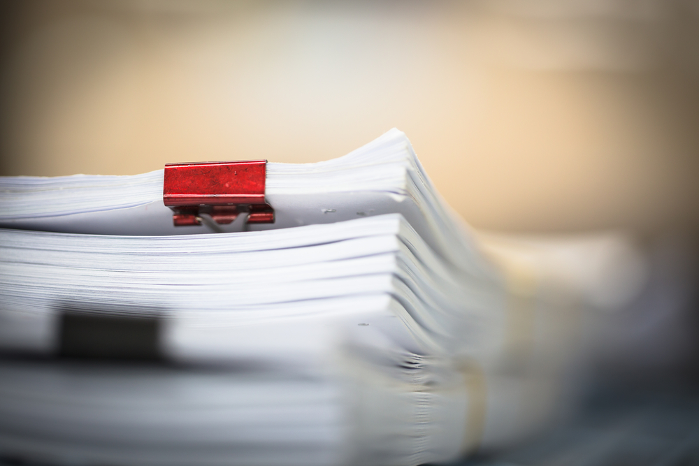 stack of government documents with red and black clips