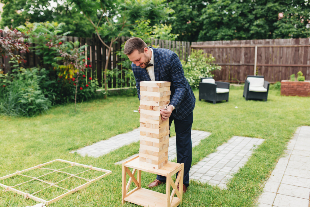 wedding guest plays jenga in an outdoor wedding reception
