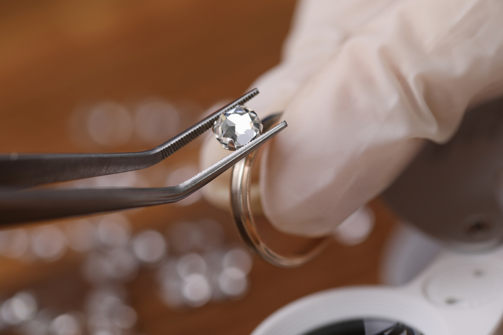 Jeweler install loose cut moissanite color in a round ring