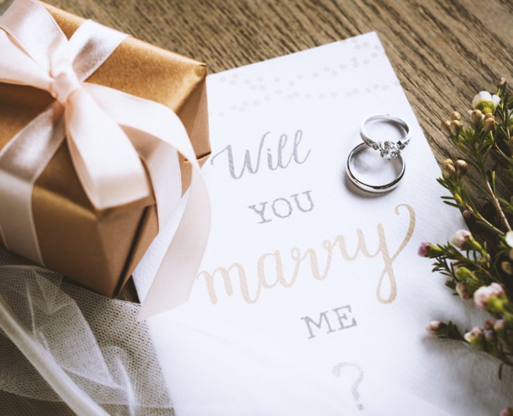 will you marry me note with a gift and flowers on the side
