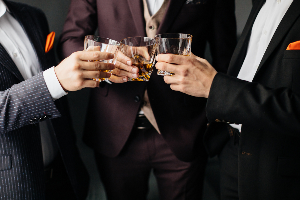 men clinking their glasses