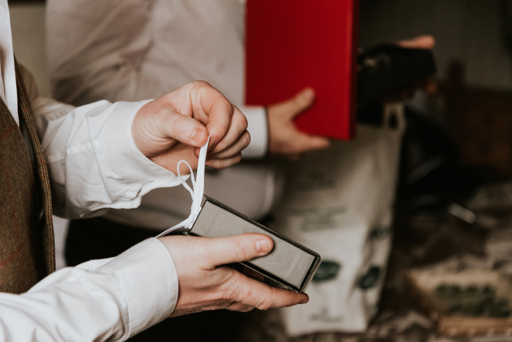 groomsman opening a gift from the groom