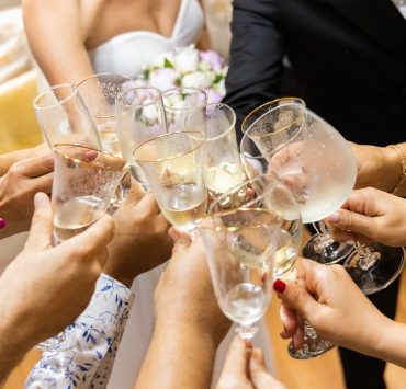 wedding couple and their friends clinking their glasses