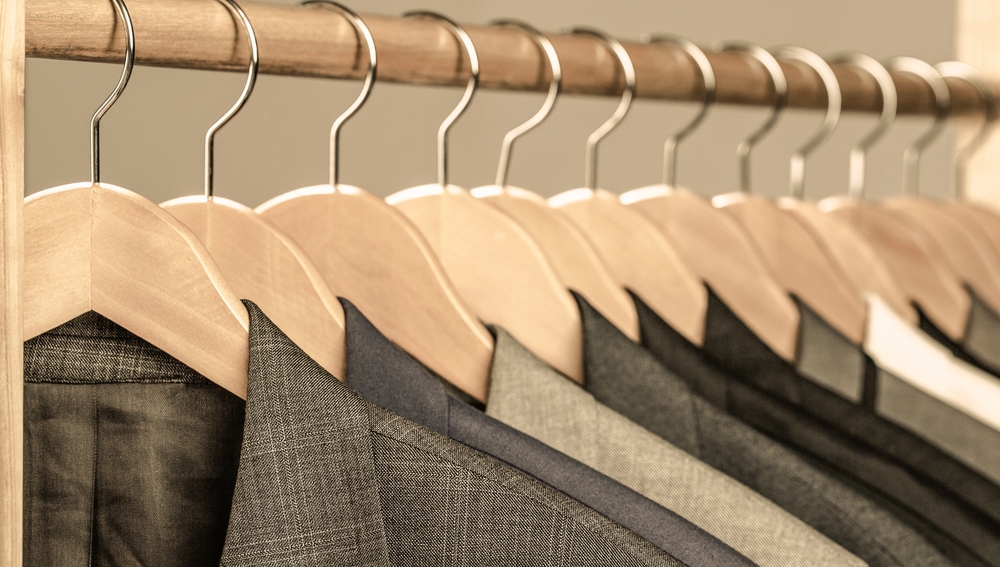 different wedding suits with blended fabric hanged on a clothes rack