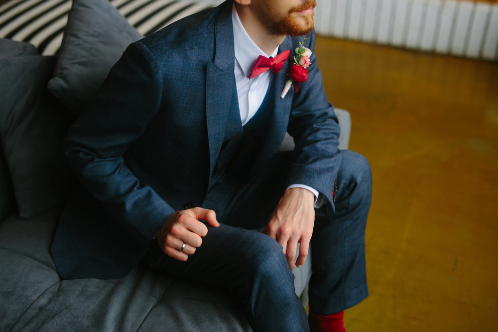 groom with a classy suit, sitting on a sofa