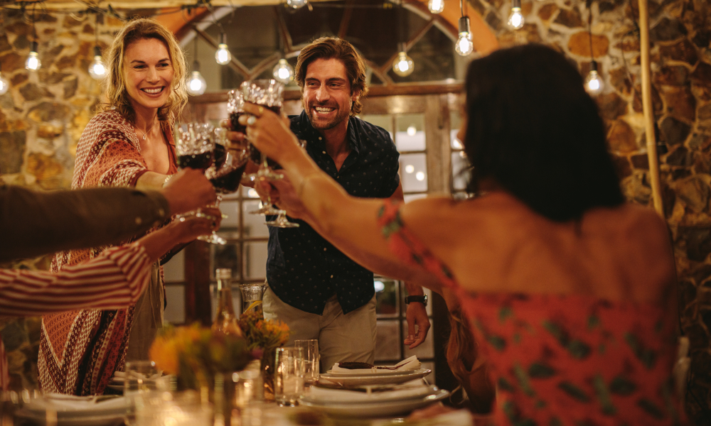 married couple having a toast with their family and friends during dinner