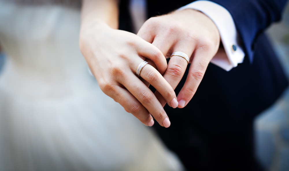 married couple's hands holding each other