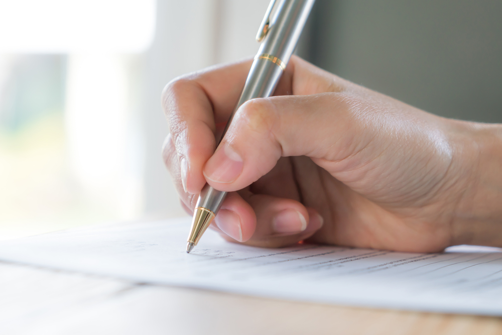 person filling out a marriage license form