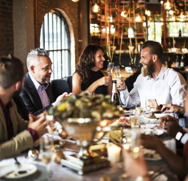 an engaged couple with friends and family at a rehearsal dinner
