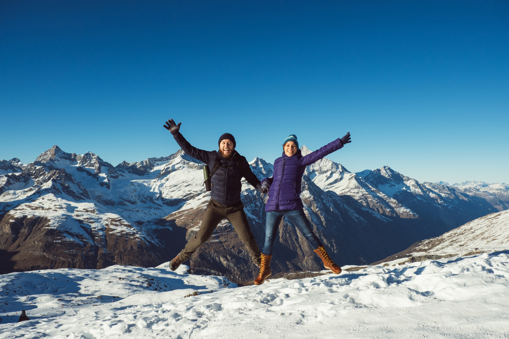 a jump shot of a couple in Switzerland