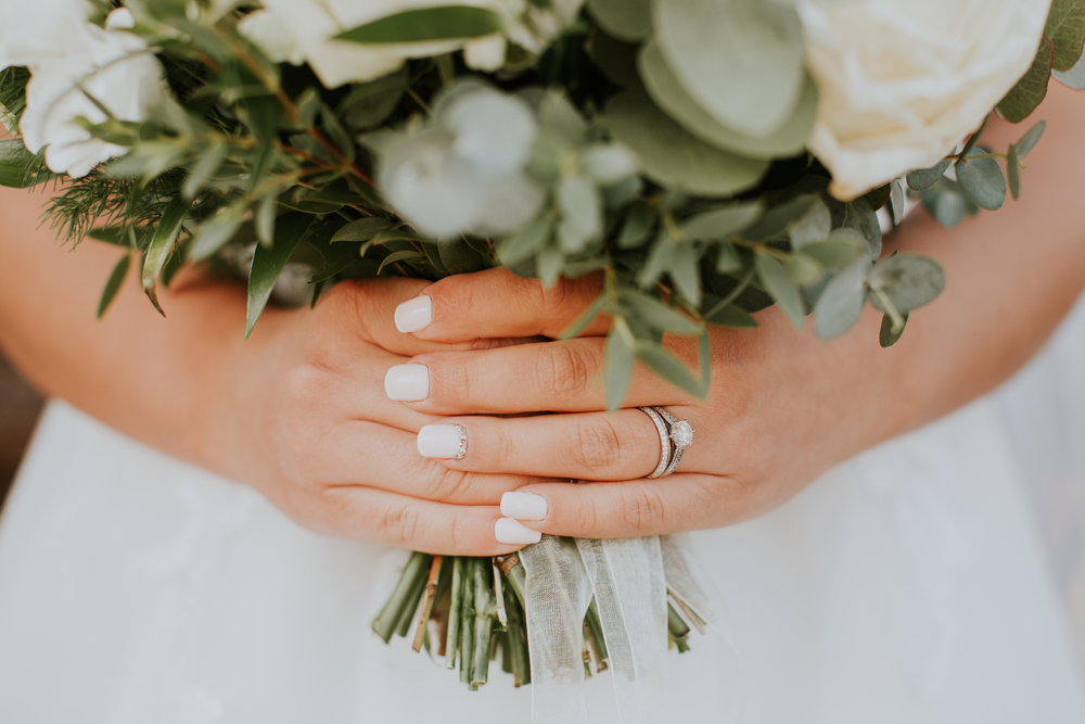 bride with white nails holding bouquet 
