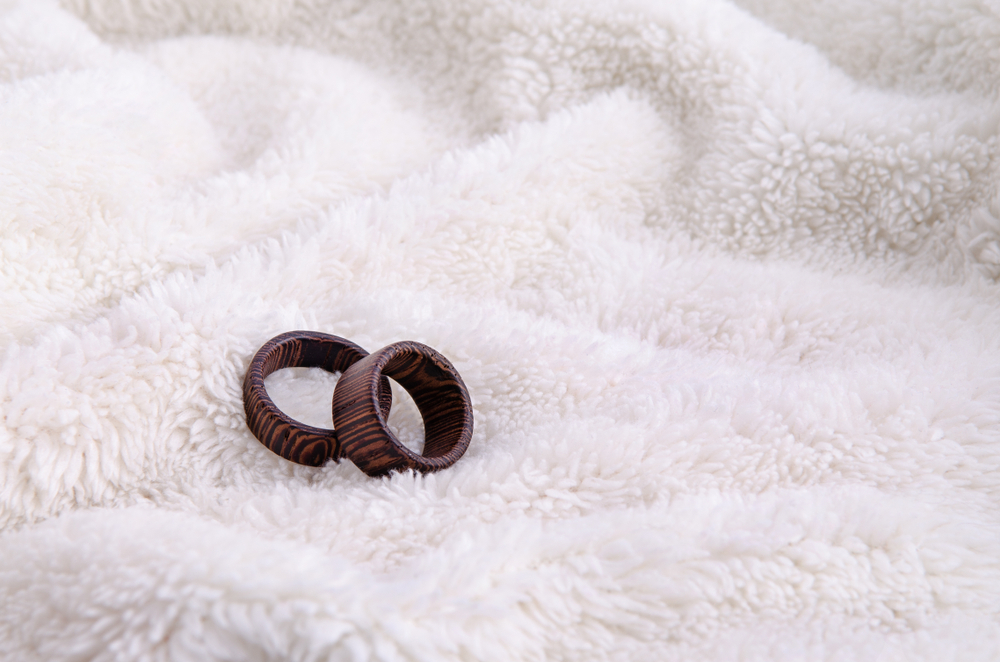 Two striped wooden rings on white fur background