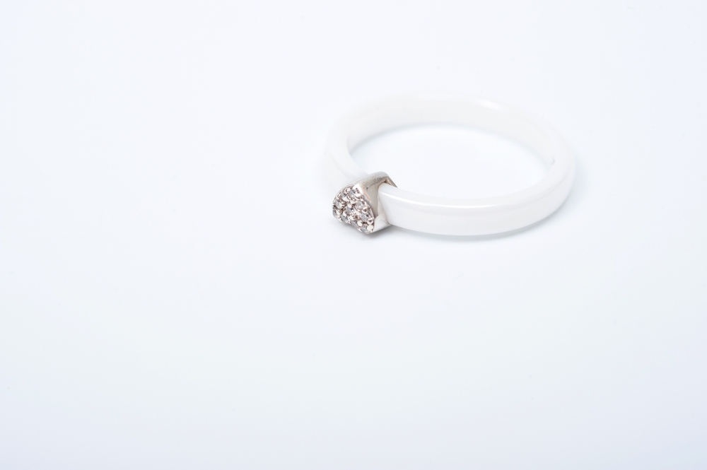 White ceramic ring with a metal heart decoratation