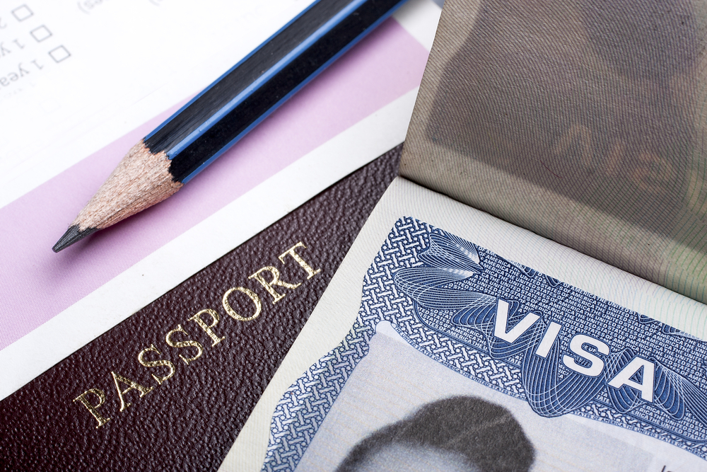 close up image of passport and visa with pencil and application form