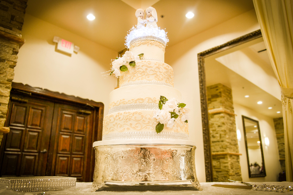 five-tiered Wedding Cake with a metal base and groom and bride figurines at the top