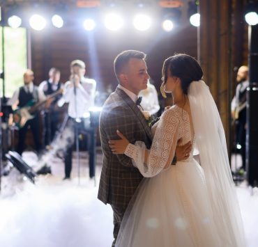 newlyweds dancing with blurred background of live band performing
