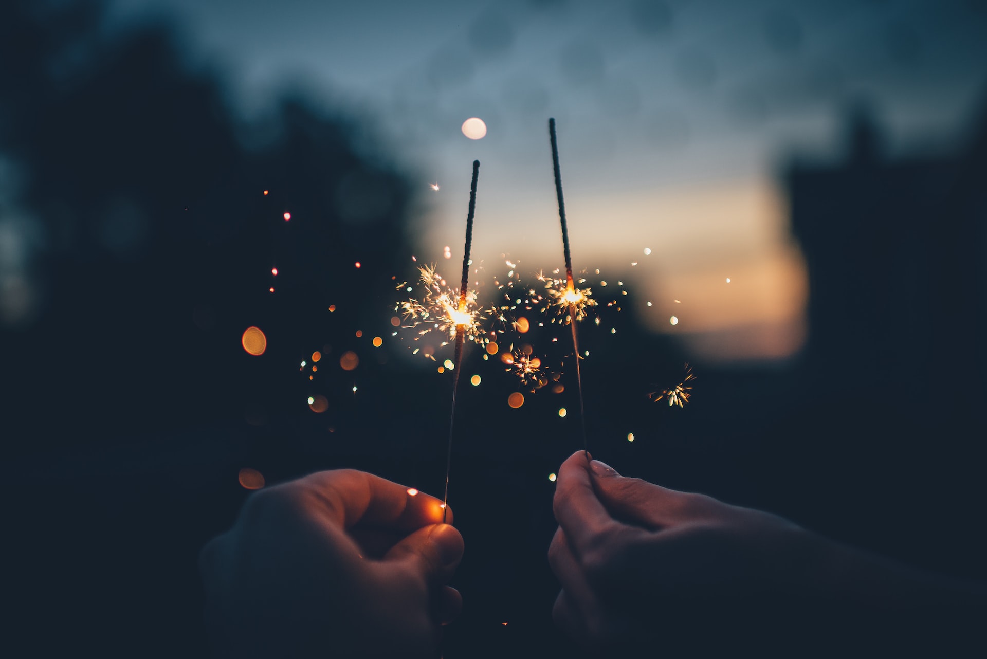 two handa holding stick sparkling fireworks on new year