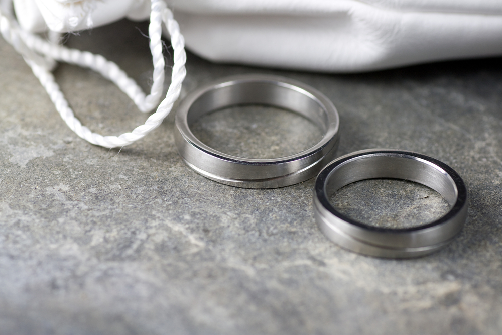 two stainless steel wedding rings on marble table