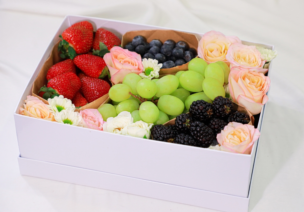 fruit and flower gift basket on white cloth surface