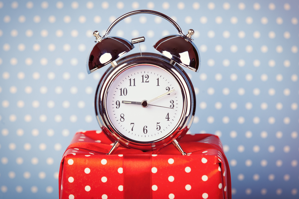 clock on top of dotted gift box with dotted background